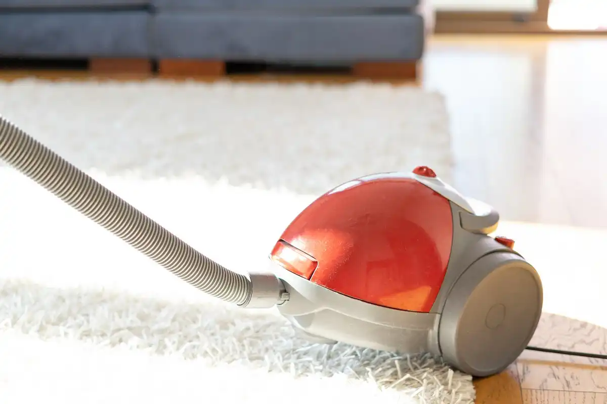 aspirateur rouge sur un tapis blanc